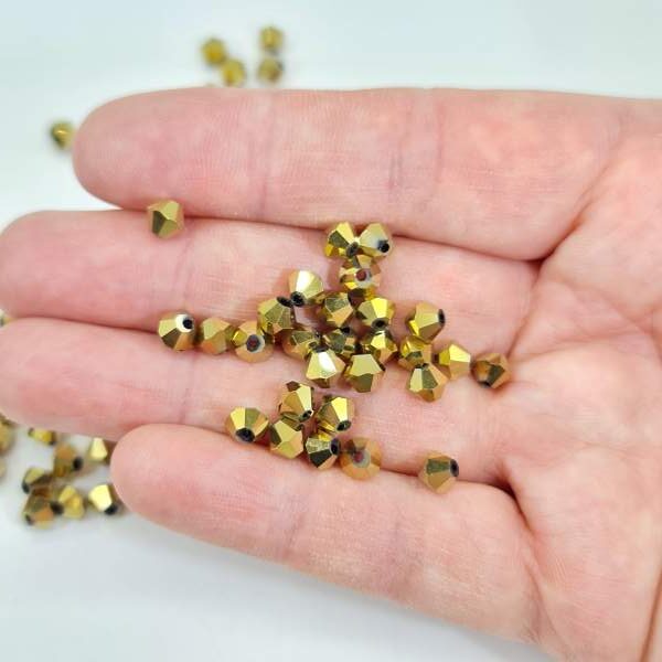 6mm gold bicone crystal beads in hand