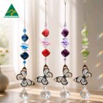 Small butterfly crystal suncatcher with stainless steel filigree butterfly, red iridised shell beads and clear crystal ball.